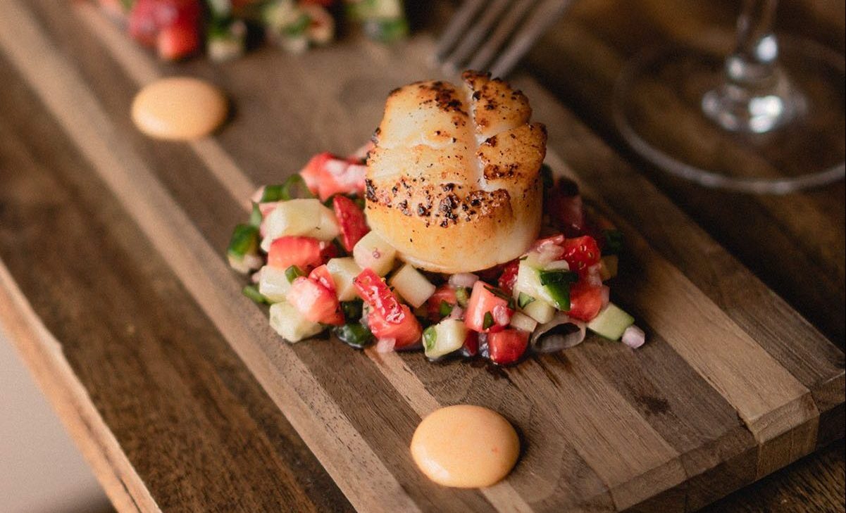 Scallops on a bed of strawberry and cucumber.